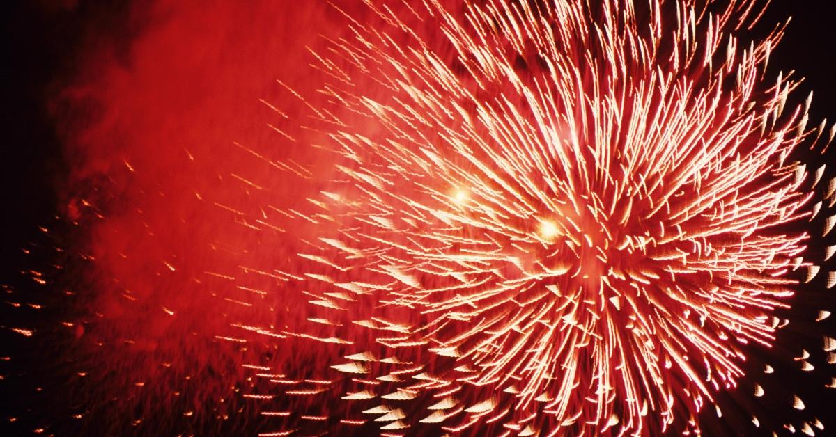 A burst of red fireworks in a night sky. 