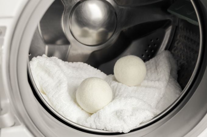 wool dryer balls and white towel in dryer.